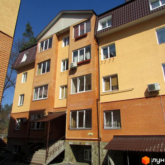 Фасад будинку на вул. Полтавська, 31е, 31з, з цегляним оздобленням та жовтою штукатуркою. Численні вікна та кондиціонери. Біля будинку видно частину сходів та навіс.