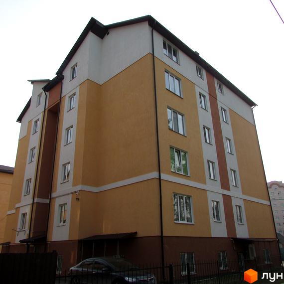 Зовнішній вигляд багатоповерхового будинку житлового комплексу на вулиці Степанівська, 10а. Будинок має жовто-білий фасад та чорний дах. На прибудинковій території видно паркан та автомобіль.