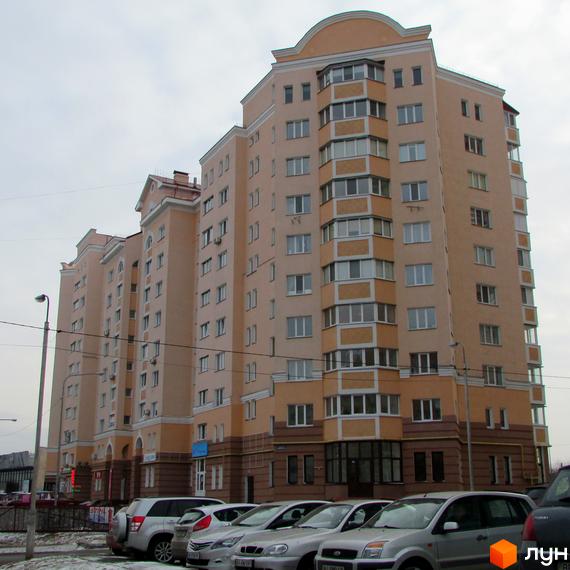 Зовнішній вигляд багатоповерхового житлового комплексу на просп. Шевченка, 6а. Навколо будинку розташовані припарковані автомобілі.