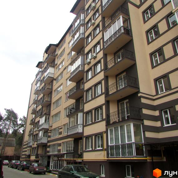 Житловий комплекс Котляревського - фасади будівель з балконами та кондиціонерами. Прибудинкова територія з автомобілями та деревами.