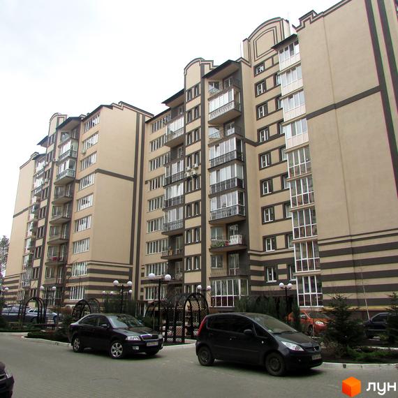 Житловий комплекс Котляревського: багатоповерховий будинок з балконами та паркуванням біля входу. Зовнішній вигляд будівлі з бежевими та коричневими елементами.