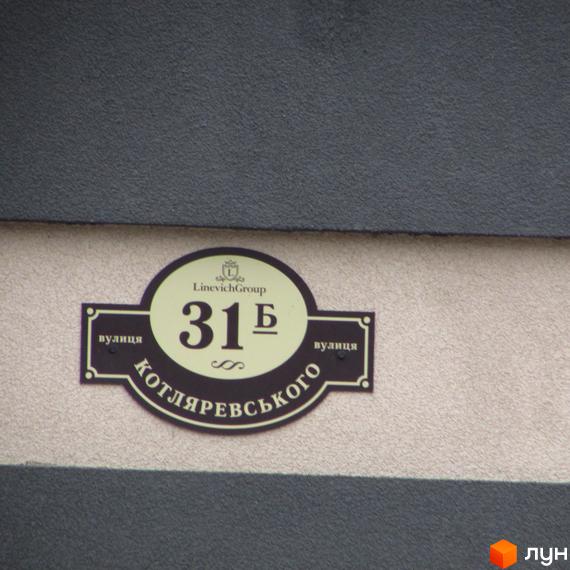 Житловий комплекс Котляревського: овальна вивіска з номером 31Б та назвою вулиці. Зовнішній вигляд будівлі з елементами дизайну.