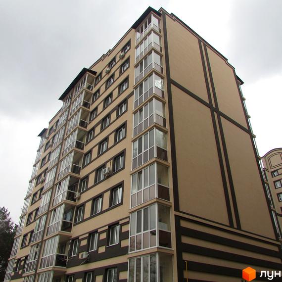 Зовнішній вигляд новобудови ЖК Котляревського. Багатоповерховий будинок з коричневими та бежевими фасадами, скляними балконами та кондиціонерами.