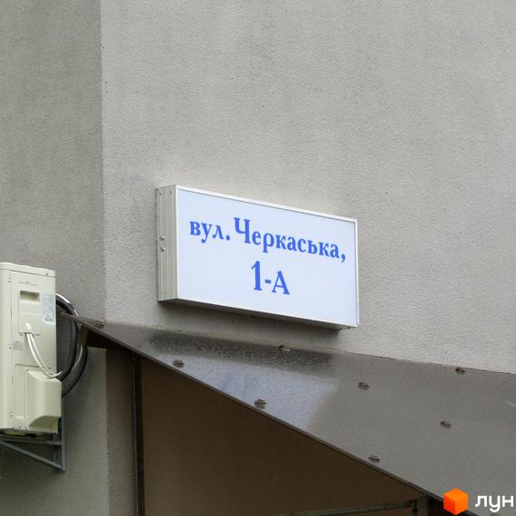 Вказівник вулиці Черкаська, 1-А на фасаді будівлі. Зовнішній вигляд новобудови ЖК Сан Сіті.