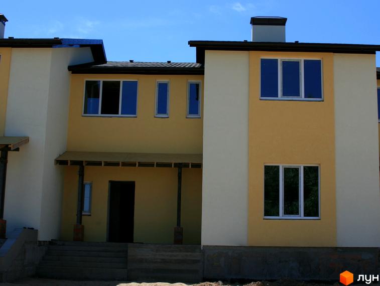 Зовнішній вигляд таунхаусів «Євродім». Двоповерхові будинки з великими вікнами та світлими фасадами. Поруч видно сходи та прибудинкову територію.