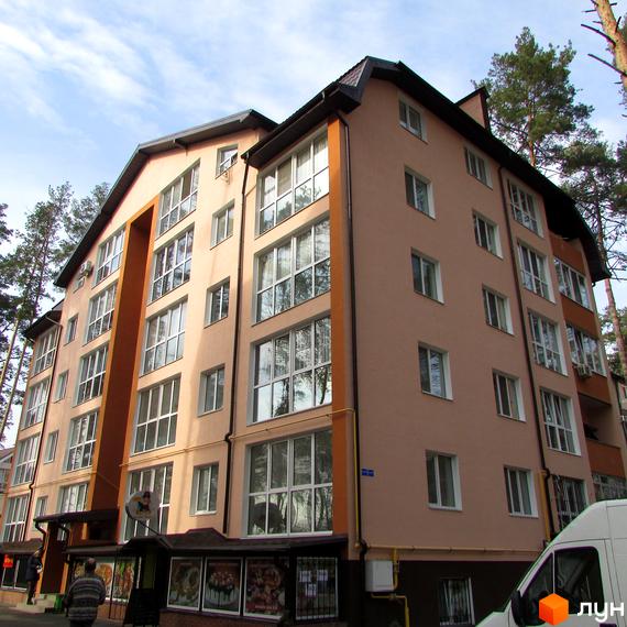 Зовнішній вигляд багатоповерхового житлового комплексу Адміральський з великою кількістю вікон та балконів. Навколо будівлі видно дерева та частина прибудинкової території.