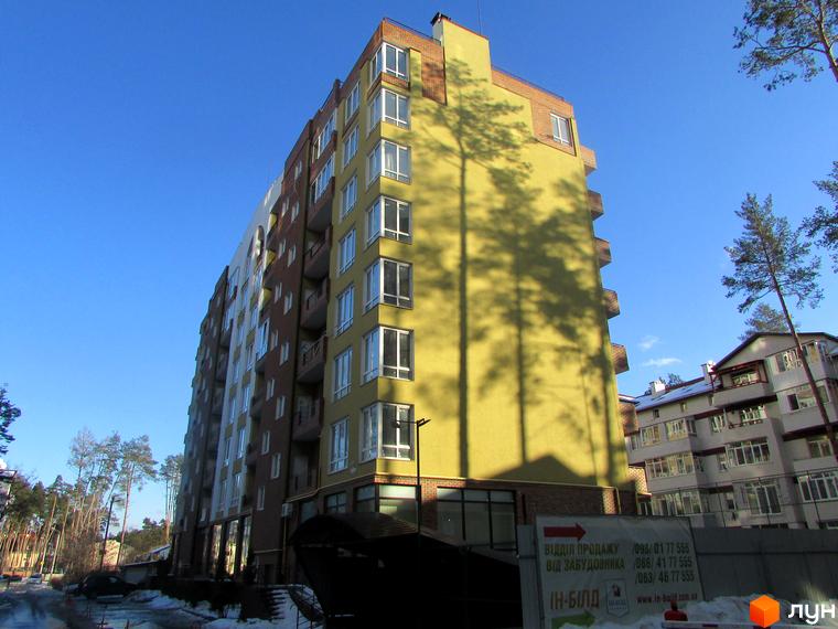 Житловий комплекс Женев'єва - багатоповерховий будинок з жовтим та коричневим фасадом, багато вікон та балконів. Навколо дерева та сусідні будинки.