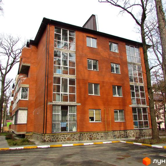 Новобудова Креатив Хаус з цегляним фасадом та великою кількістю вікон. Біля будинку облаштована прибудинкова територія.