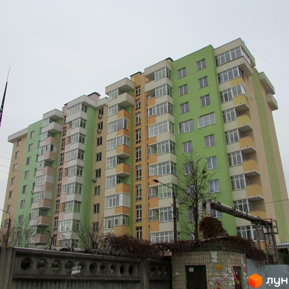 Зображення багатоповерхового будинку в Житловому комплексі Київські Зорі. На фото видно фасад будинку з балконами та прибудинкову територію.