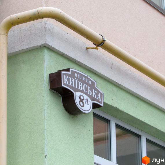Зовнішній вигляд будинку. Адресна табличка з написом вулиця Київська, 8А. Фото будинку Житлового комплексу Київські Зорі.