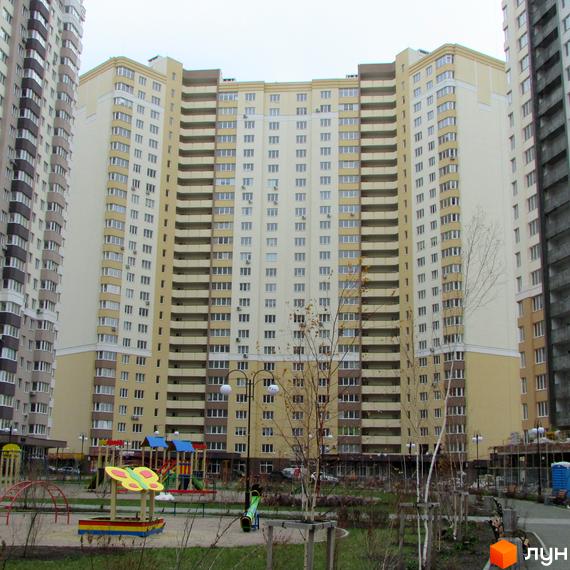 Зображення багатоповерхового будинку в Житловому комплексі Лісовий квартал. На передньому плані дитячий майданчик та зелена зона.