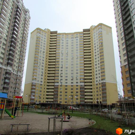 Зображення багатоповерхового будинку в Житловому комплексі Лісовий квартал. На передньому плані дитячий майданчик з гірками та гойдалками.