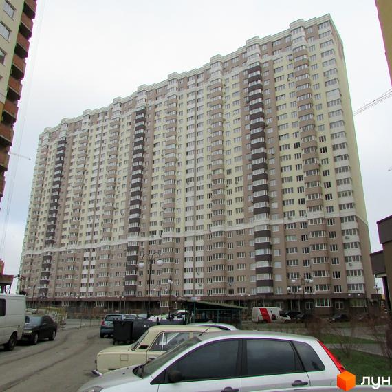 Зображення багатоповерхового будинку Житлового комплексу Лісовий квартал. На передньому плані припарковані автомобілі.