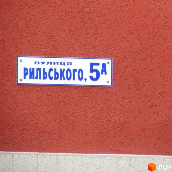 Фото таблички з назвою вулиці РИЛЬСЬКОГО, 5А на фасаді будинку. Житловий комплекс Рильського.