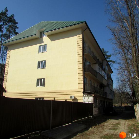 Зображення фасаду будинку по вулиці Полтавська, 29. Багатоповерхова будівля з балконами та зеленою покрівлею, огороджена парканом.