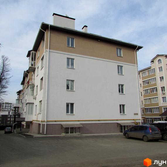 Зображення фасаду будинку за адресою вул. Новооскольська, 8в. Багатоповерхова будівля з вікнами та припаркованими автомобілями.