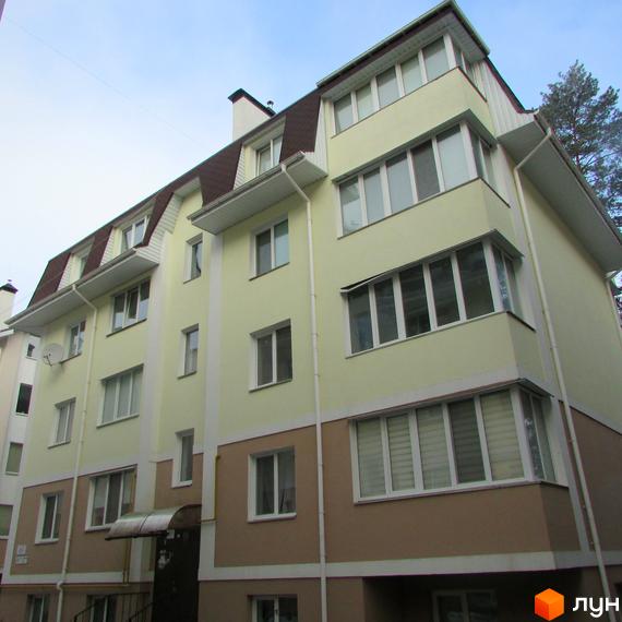 Зовнішній вигляд чотириповерхового будинку в Житловому комплексі Авангард на Лісовій. Світла будівля з мансардним дахом та великими вікнами.