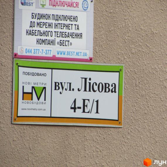 Зображення будинку на вулиці Лісова 4-Е/1. Табличка з назвою вулиці та номером будинку на фасаді новобудови.