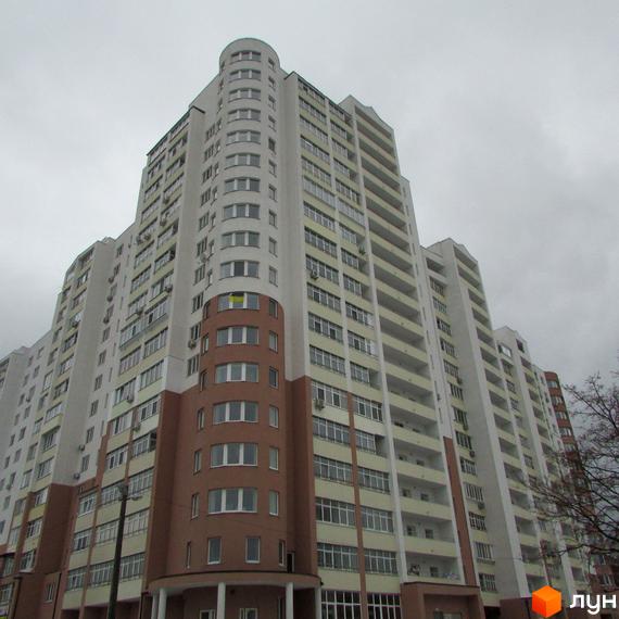 Новобудова Княжа гора: багатоповерховий житловий будинок зі світлим фасадом та коричневими елементами. Видно численні вікна та балкони.