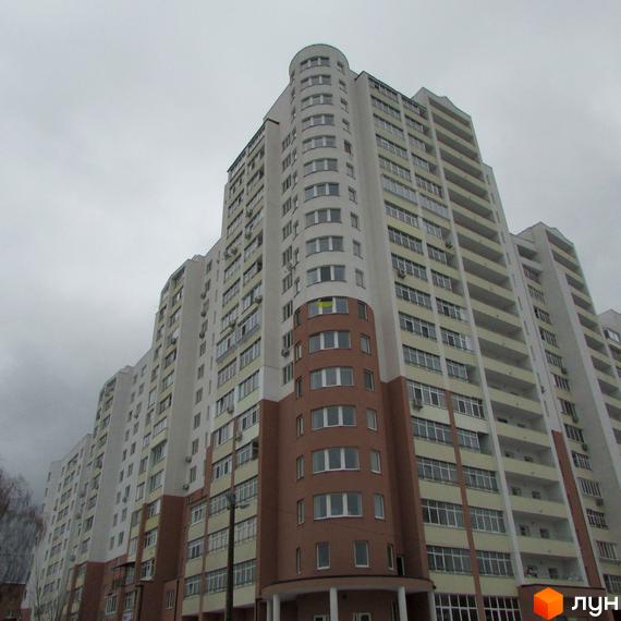 Багатоповерховий житловий комплекс Княжа гора з білими та коричневими фасадами, балконами та округлою секцією.