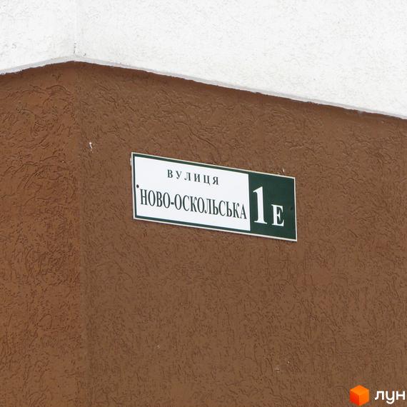 Фасад будинку Житлового комплексу Фортуна коричневого кольору з табличкою вулиці Ново-Оскольська 1Е.