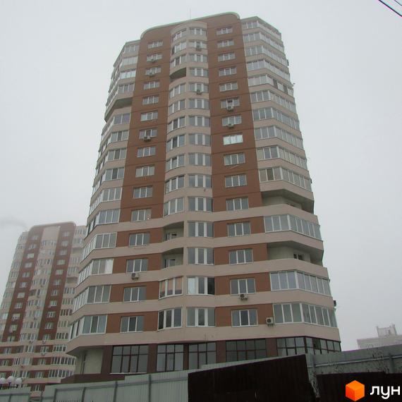 Житловий комплекс Шоколад: високий багатоповерховий будинок з коричнево-бежевим фасадом та численними вікнами. Поруч розташована ще одна схожа будівля.