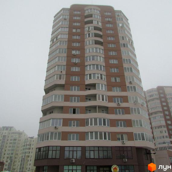 Житловий комплекс Шоколад: висотна будівля з коричневими та світлими фасадами, великими вікнами та балконами. На перших поверхах комерційні приміщення.