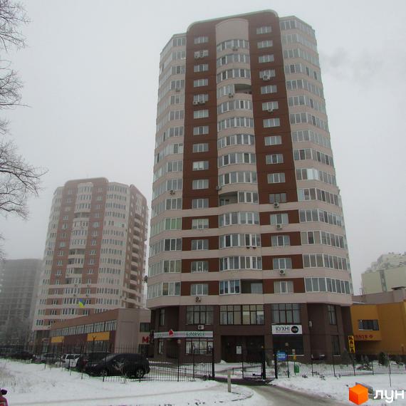 Житловий комплекс Шоколад: два багатоповерхові будинки з коричневими та світлими фасадами, великими вікнами. Навколо сніг, видно комерційні приміщення на перших поверхах.