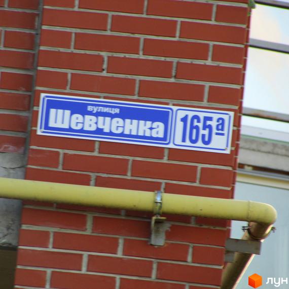 Будинок житлового комплексу Левада з табличкою вулиця Шевченка 165а. Зовнішній вигляд фасаду будівлі.