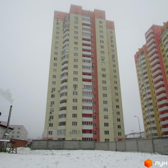 Житловий комплекс на вул. Симона Петлюри (Черняховського), 36, 36а, 36б. Багатоповерхові будинки з балконами на тлі хмарного неба та засніженої території.