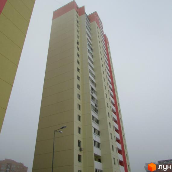 Високоповерховий житловий комплекс на вул. Симона Петлюри (Черняховського), 36, 36а, 36б. Будинок має світло-жовтий фасад з червоними елементами та балконами. Поруч видно ліхтарний стовп та сусідні будівлі.