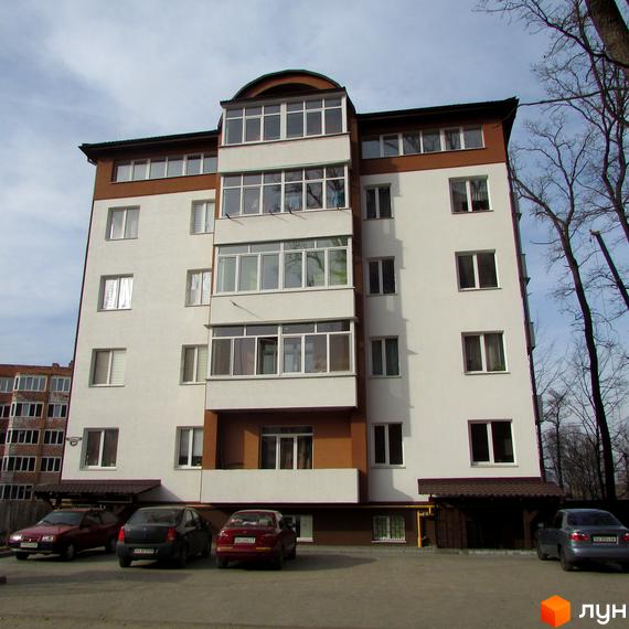 Житловий комплекс Дуброва: багатоповерховий будинок з коричневими та білими фасадами, заскленими балконами та прибудинковою територією з автомобілями.