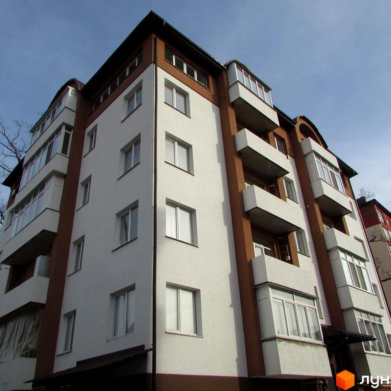 Зовнішній вигляд житлового комплексу Дуброва: багатоповерховий будинок з біло-коричневим фасадом та скляними балконами.