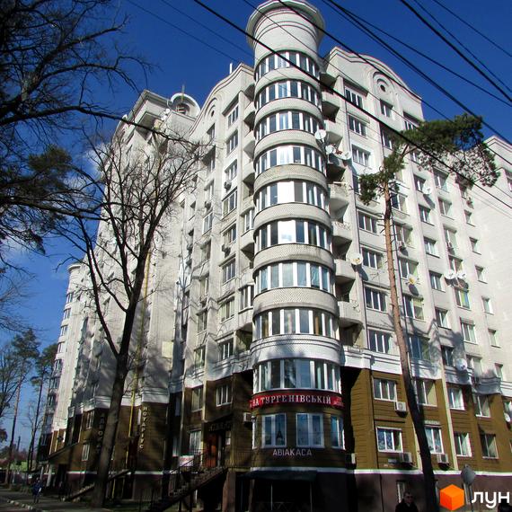 Новобудова ЖК Тургенівська з круглою вежею та панорамними вікнами. Зовнішній вигляд будинку з цегляним фасадом та балконами.