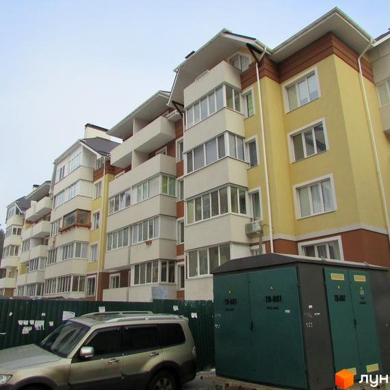 Фасад житлового комплексу на вул. Лісовій, 6к, з балконами та вікнами. Поруч прибудинкова територія з автомобілем та трансформаторною підстанцією.