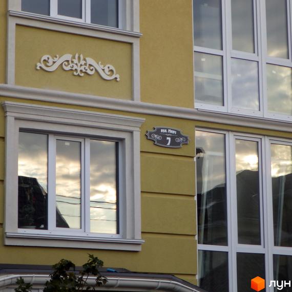 Фасад житлового комплексу Софіївський пасаж з декоративним елементом та табличкою з номером будинку. Зовнішній вигляд новобудови.