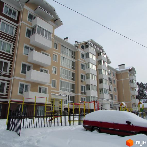 Зовнішній вигляд житлового комплексу на вул. Мечникова, 103, з балконами та великими вікнами. На прибудинковій території видно дитячий майданчик та засніжений автомобіль.