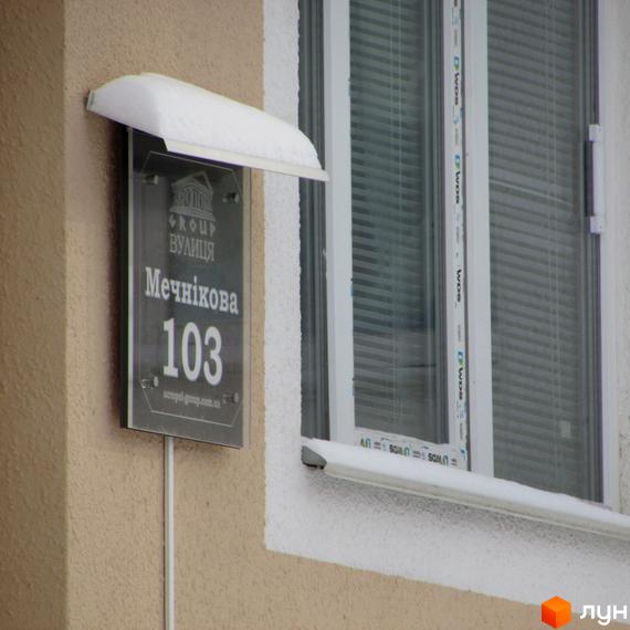 Адрес новобудови: вул. Мечникова, 103. Зовнішній вигляд будівлі та табличка з адресою комплексу.