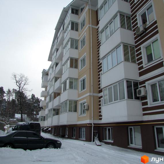 Житловий комплекс на вул. Мечникова, 103, з біло-бежевим фасадом та коричневими смугами. Поруч засніжена територія з припаркованими автомобілями.