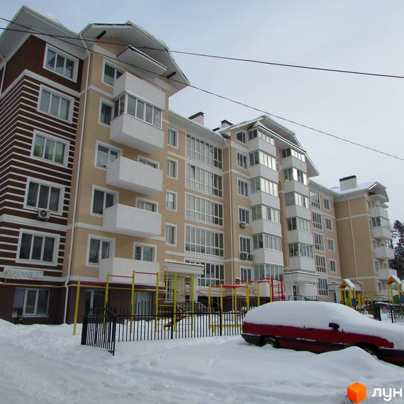 Зовнішній вигляд житлового комплексу на вул. Мечникова, 103. Навколо будинку розташований дитячий майданчик та засніжена прибудинкова територія.