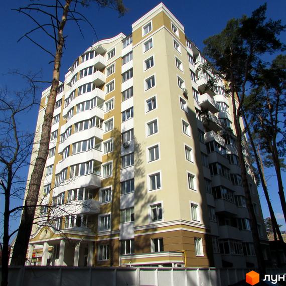 Фасад новобудови ЖК 8 Марта з балконами та вікнами, оточений деревами. Зовнішній вигляд будинку та прибудинкової території.