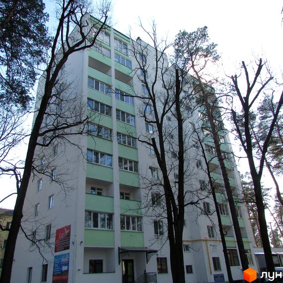 Житловий комплекс Сосновий двір - багатоповерховий будинок з біло-зеленим фасадом, оточений деревами. Зовнішній вигляд новобудови, що гармонійно вписується в природний ландшафт.