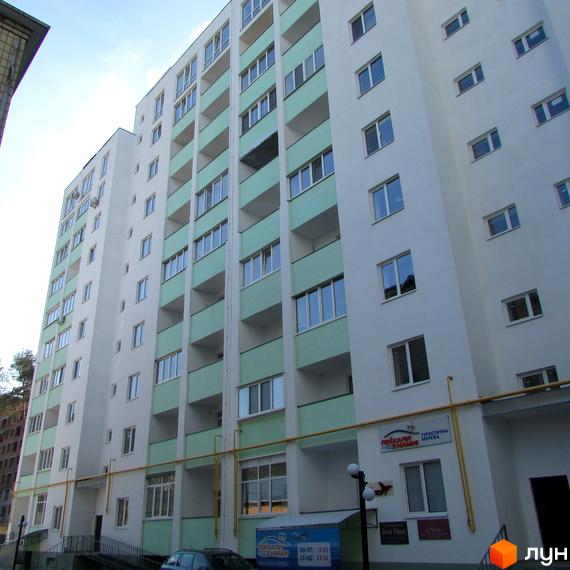 Зовнішній вигляд багатоквартирного будинку ЖК Сосновий двір з балконами світло-зеленого кольору. На фасаді видно вікна та кондиціонери. Біля будинку розташована прибудинкова територія.