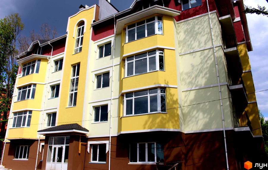 Багатоповерховий будинок з жовтим та кремовим фасадом. Вікна з білими рамами, балкони. ЖК Ваша квартира - сучасне житло для комфортного життя.