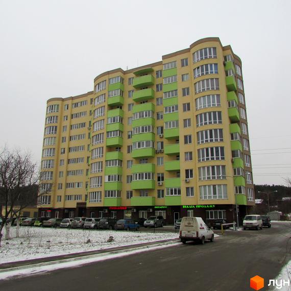 Житловий комплекс Зірка Дніпра – багатоповерхова жовто-зелена новобудова з численними балконами. Біля будинку розташована парковка та дорога.