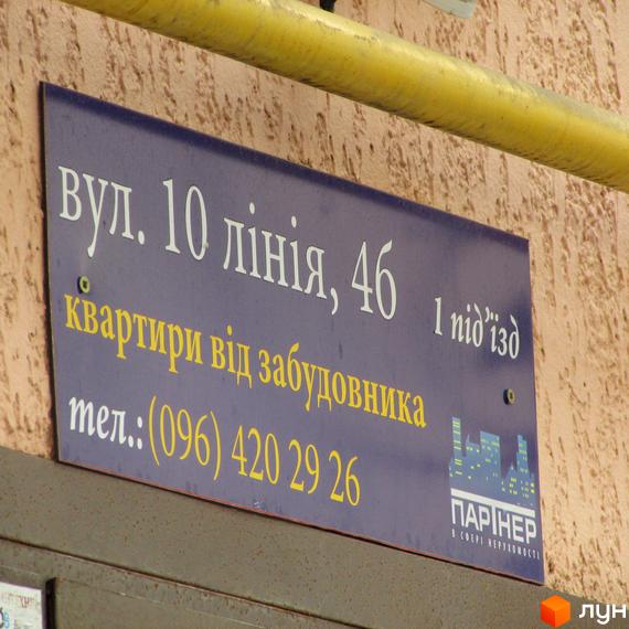 Житловий комплекс Сосновий бір, вул. 10 лінія, 46. Квартири від забудовника, тел.: (096) 420 29 26. На вивісці зображено назву житлового комплексу та контактну інформацію.