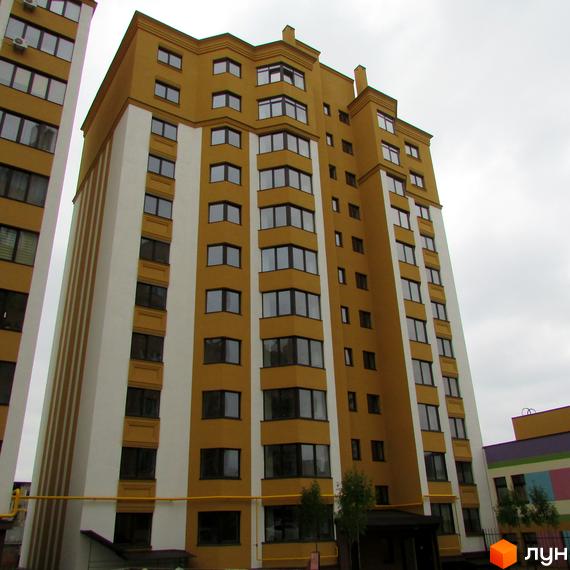 Житловий комплекс Щасливий на Петропавлівці – багатоповерховий будинок з жовто-білим фасадом та великою кількістю вікон. Сучасна новобудова з акуратною прибудинковою територією.