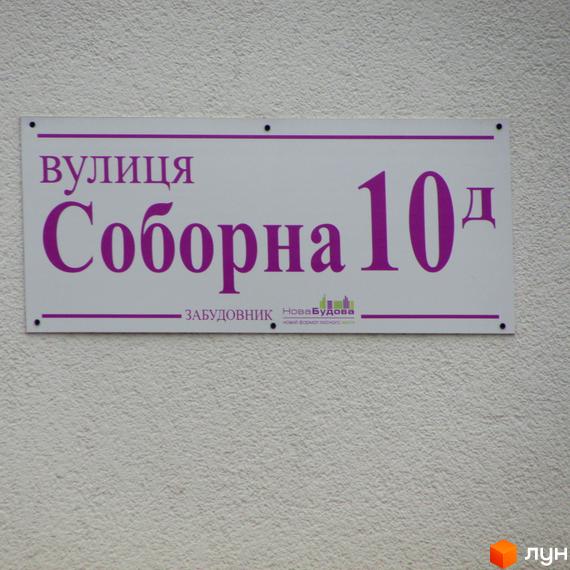 Вулиця Соборна 10д. На вивісці також є логотип забудовника Нова Будова.