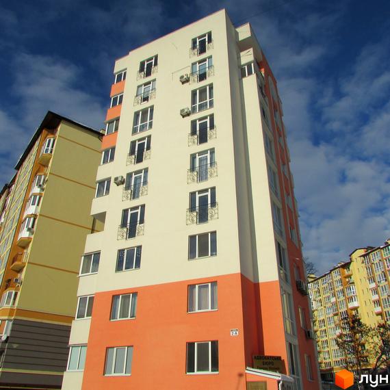 Житловий комплекс Квітневий – багатоповерховий будинок з біло-помаранчевим фасадом та балконами. Навколо видно інші новобудови.