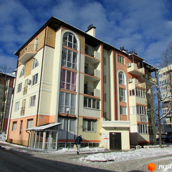 Житловий комплекс Квітневий - багатоповерховий будинок з арочними вікнами та балконами. Навколо будинку засніжена територія та дерева.